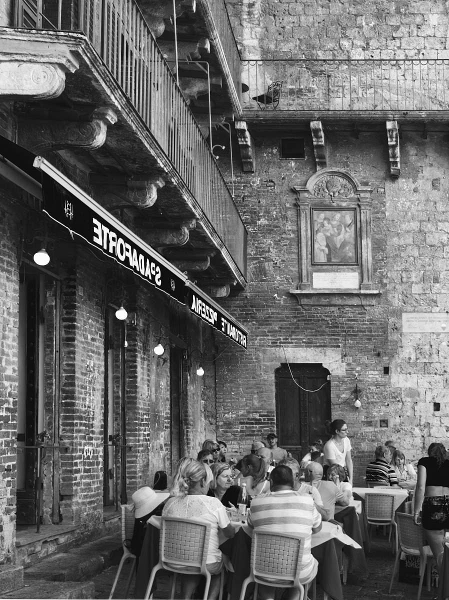 human gray-scale photo of restaurant facade brick