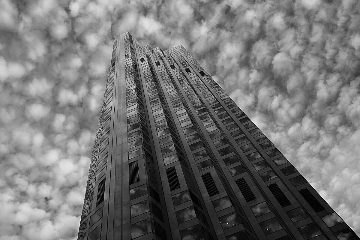 building grayscale low-angle photo of high-rise building under cloudy sky office building