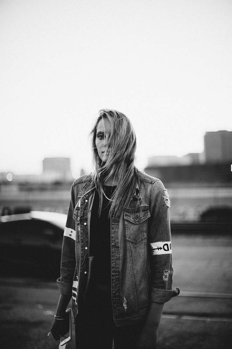 people grayscale of woman wearing jacket holding smartphone woman
