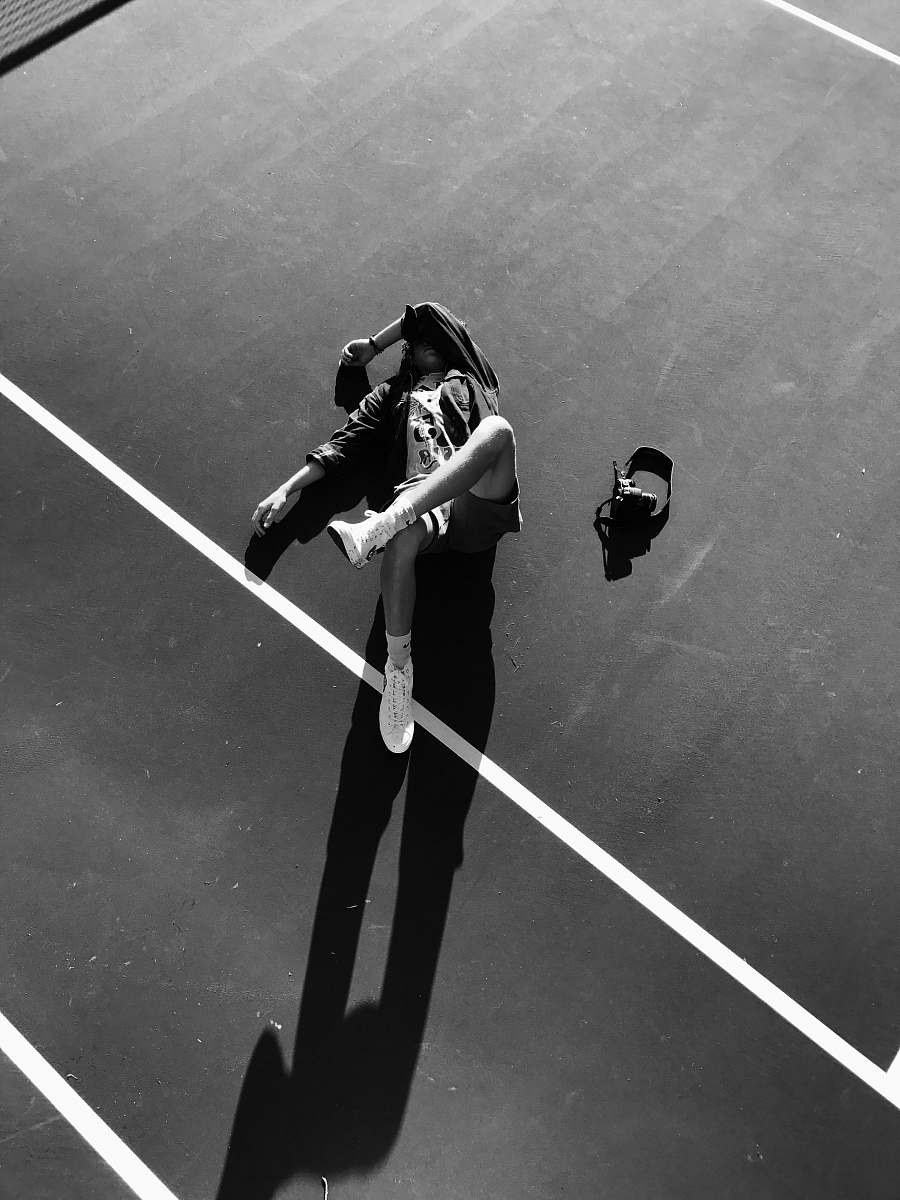 human grayscale photo of athlete lying down on court person