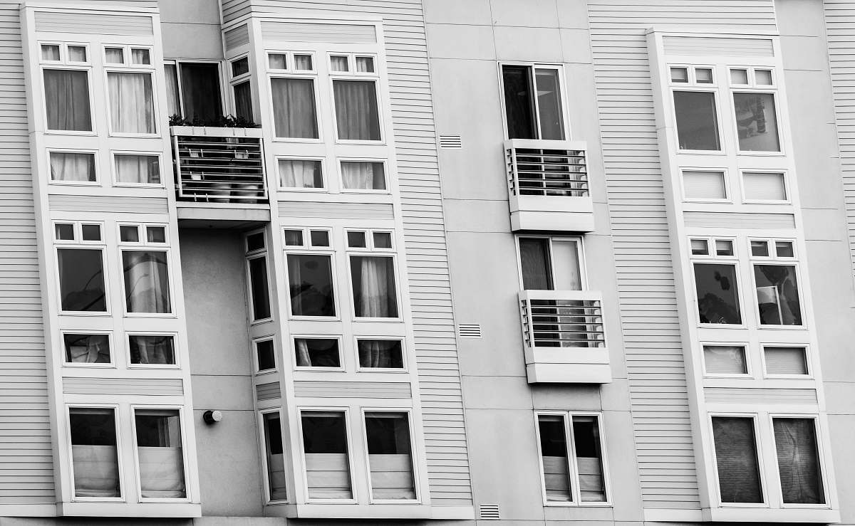 window grayscale photo of building air conditioner