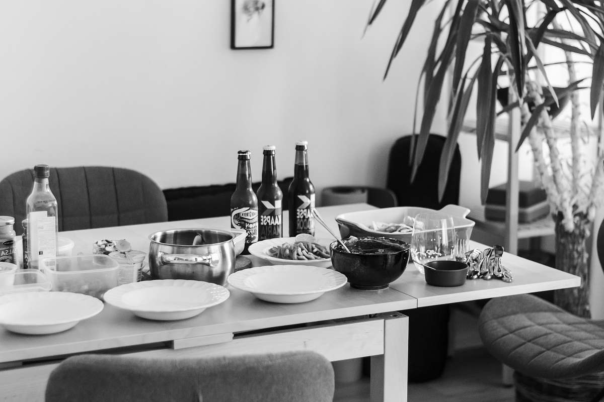 furniture grayscale photo of dining table with plates and bowls dining table
