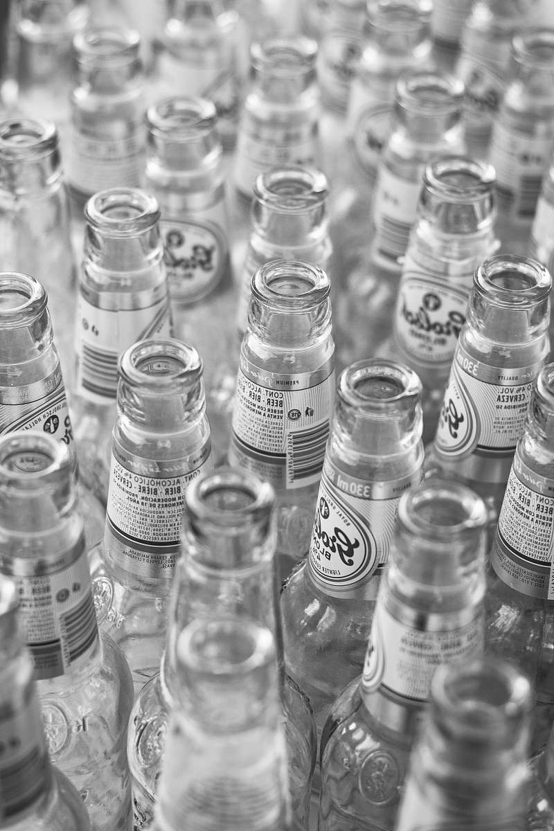 grey grayscale photo of glass bottles jar