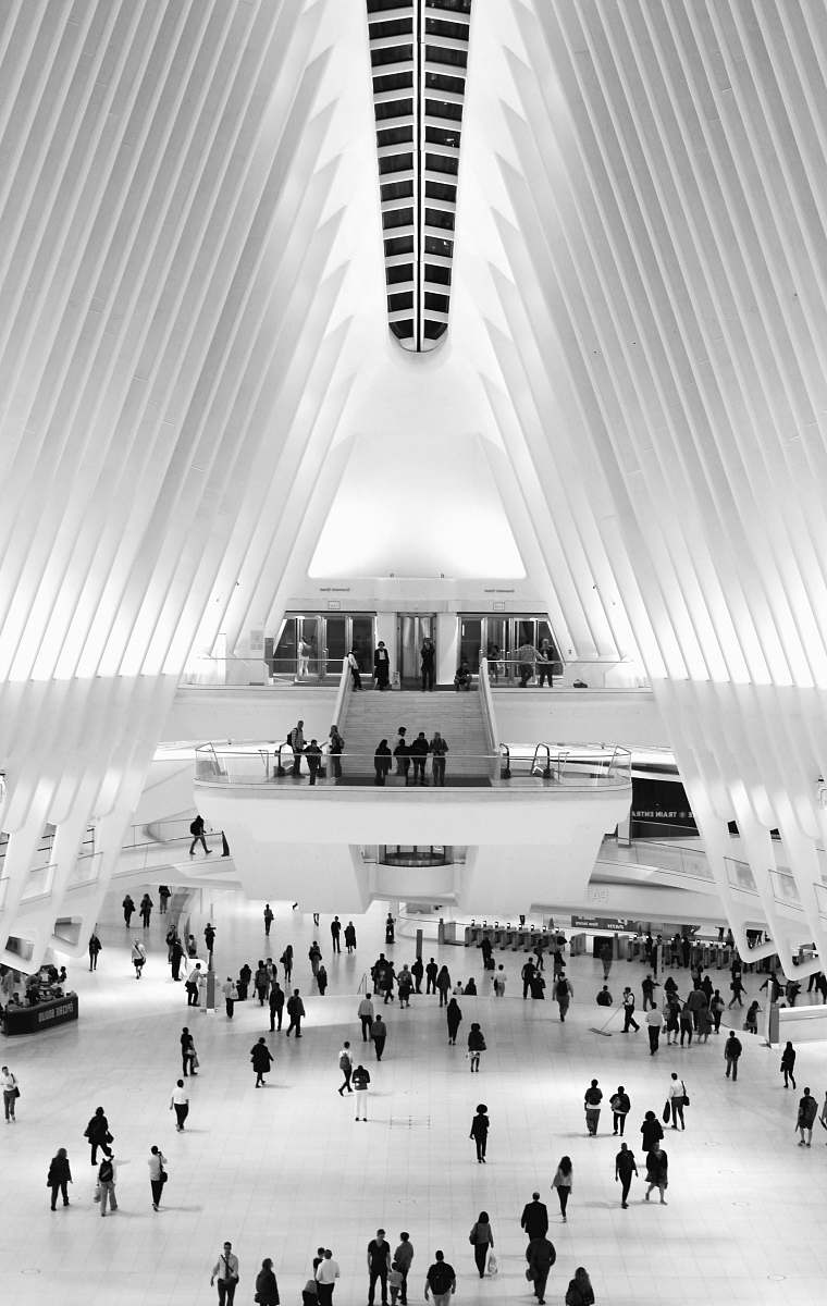 human grayscale photo of group of people standing inside white and black building person