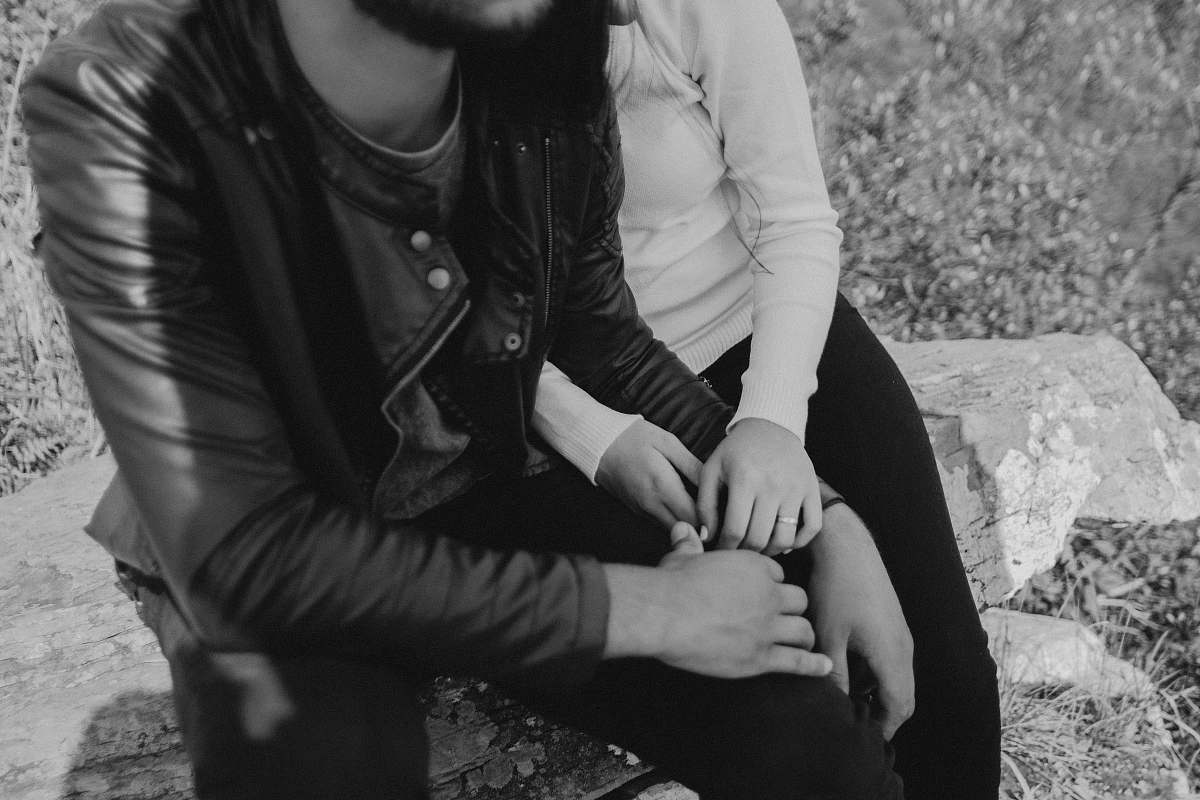 human grayscale photo of man and woman sitting on bench people