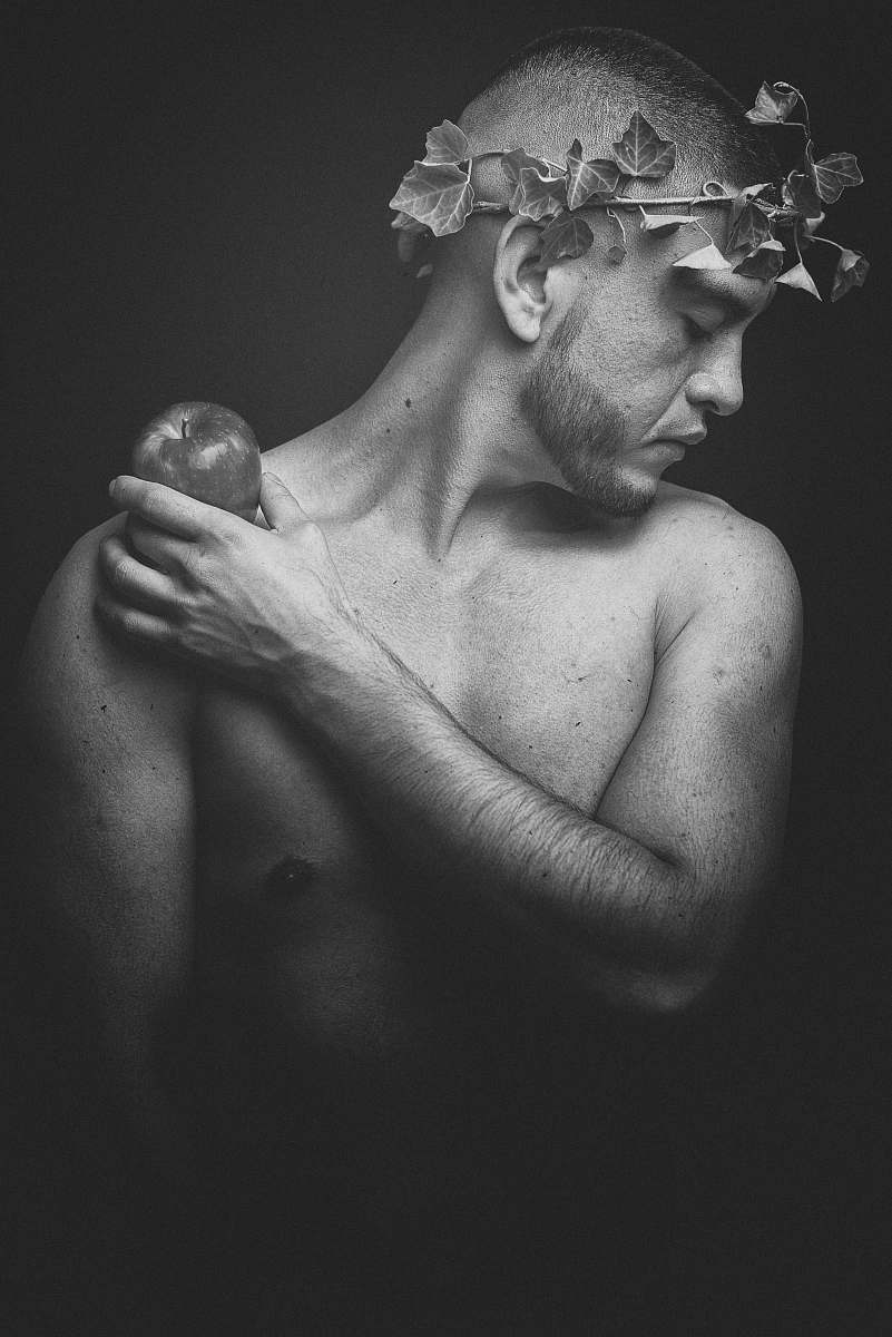 grey grayscale photo of man holding apple fruit human