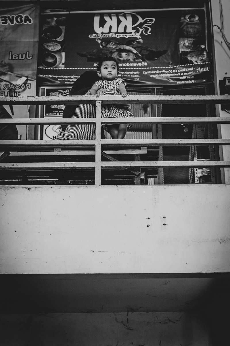 surabaya grayscale photo of man holding baby while sitting on sofa indonesia