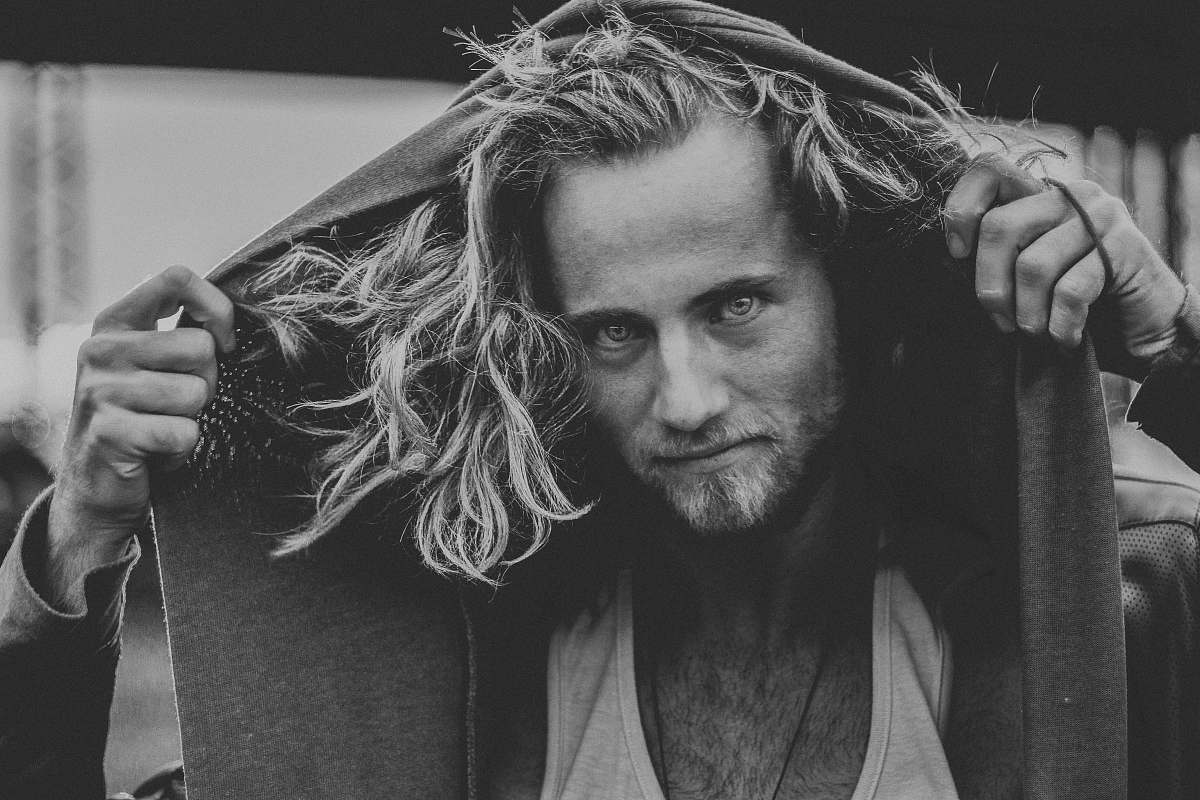 human grayscale photo of man hooding his hoodie jacket person