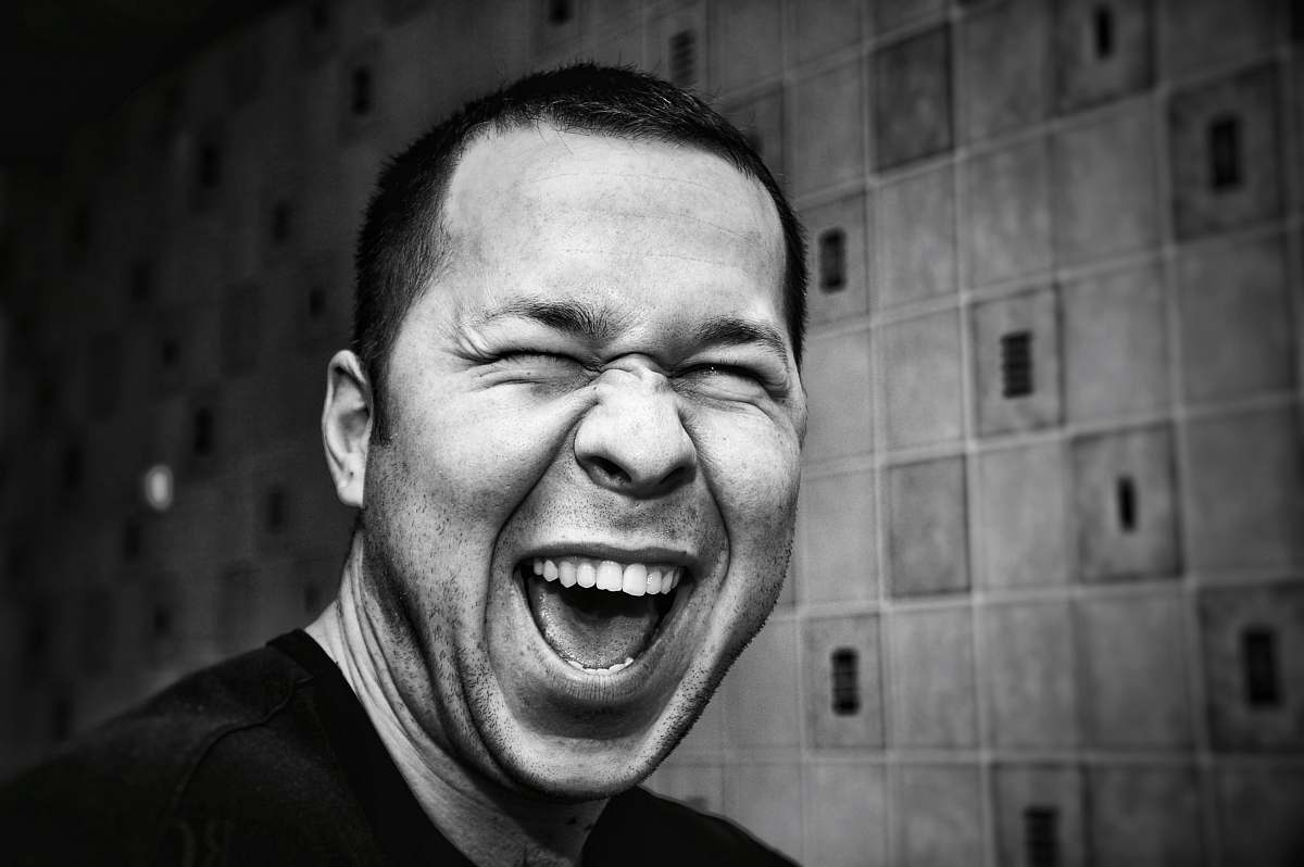 person grayscale photo of man making silly face face