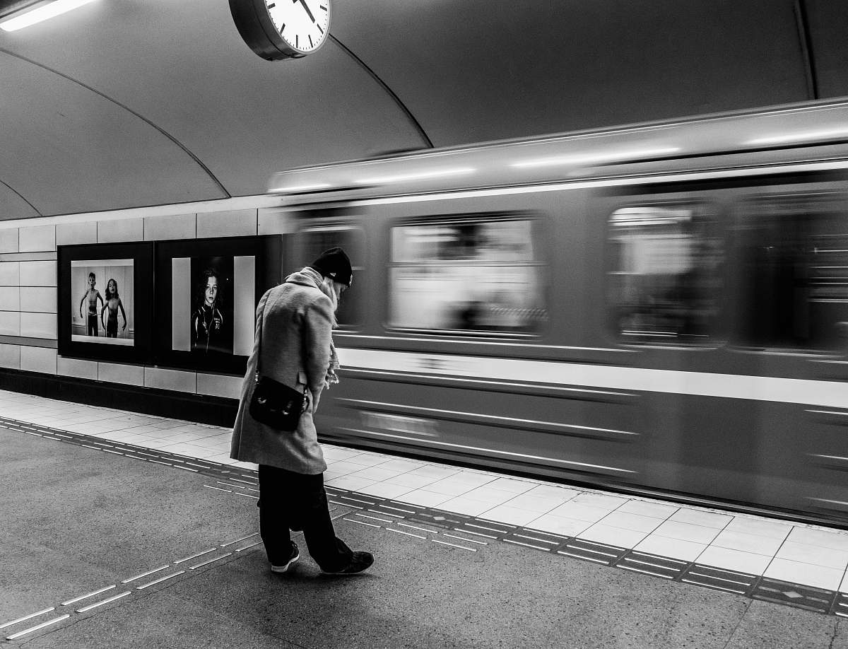 terminal grayscale photo of man on train station vehicle