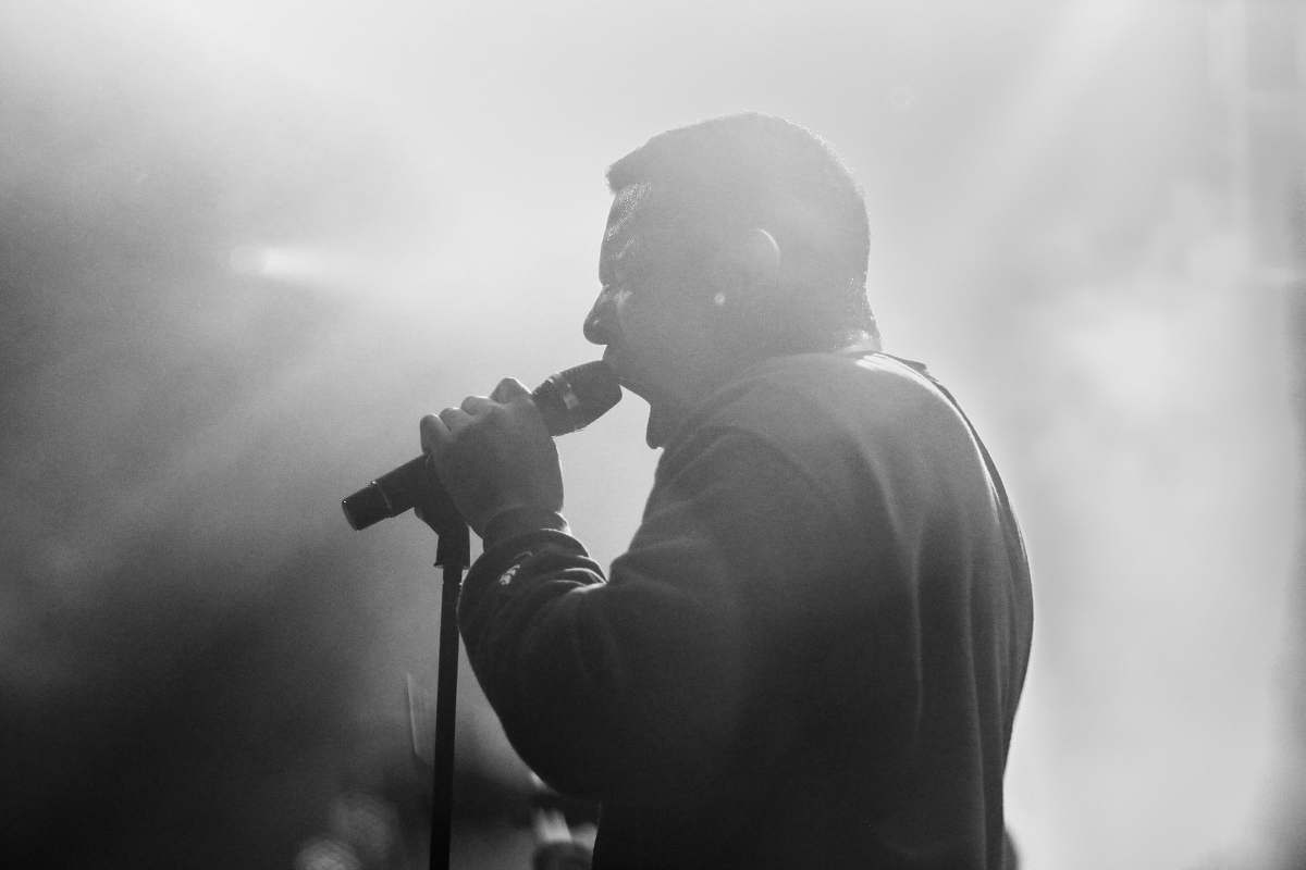 person grayscale photo of man using microphone human
