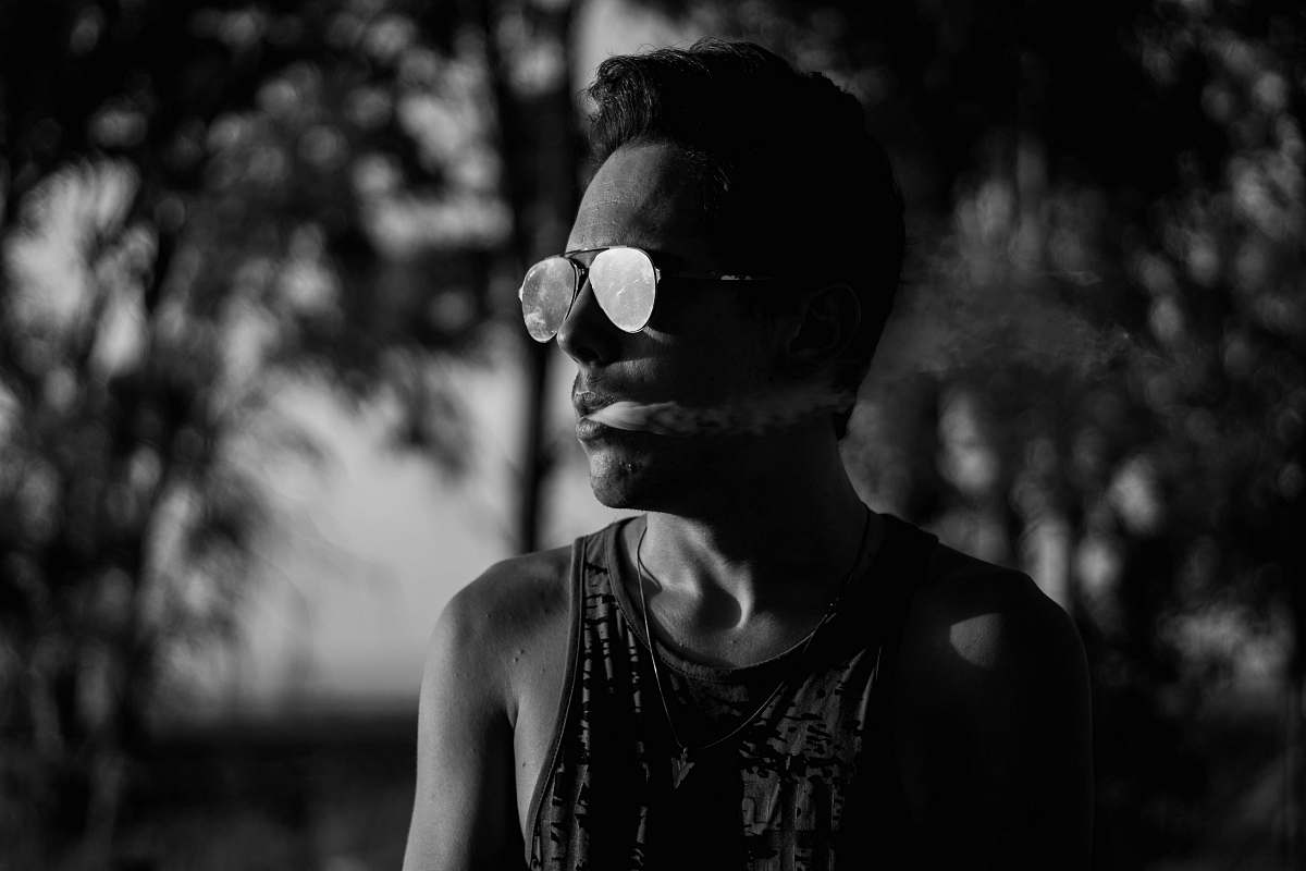 person grayscale photo of man with smoke on its mouth people