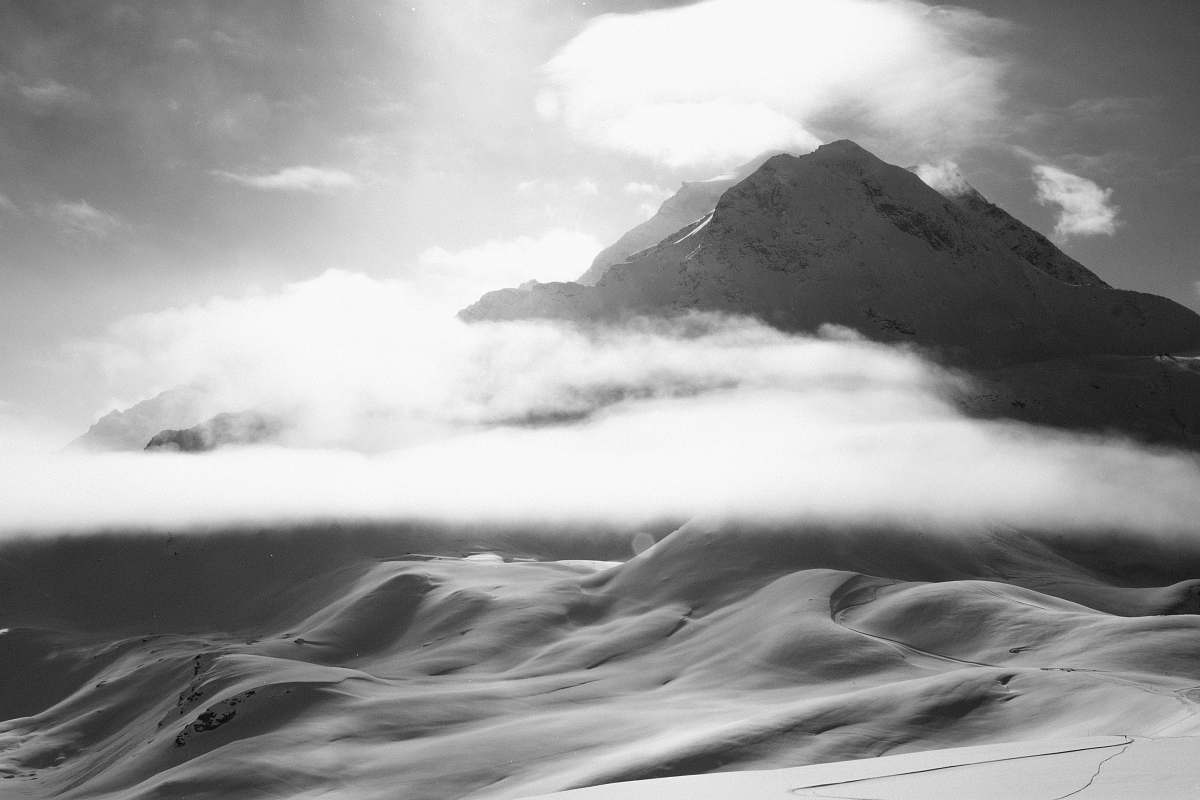 mountain grayscale photo of mountain covered by fogs alps