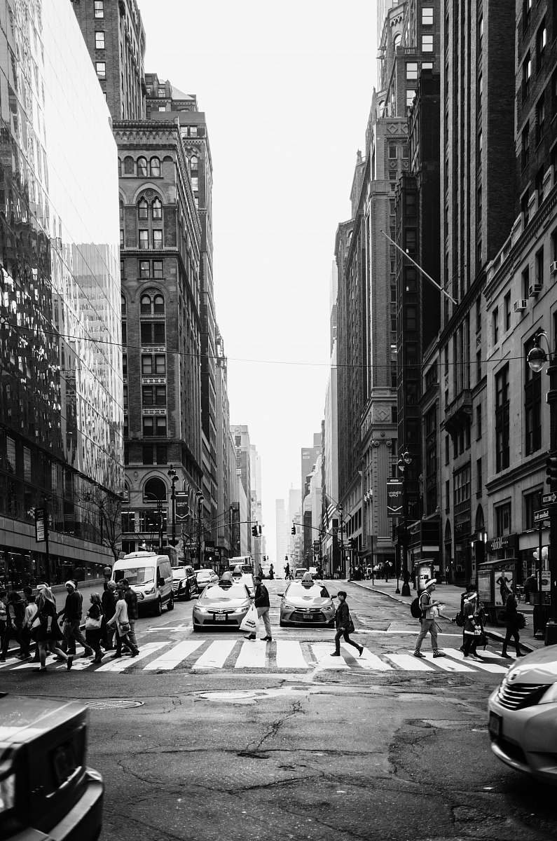 person grayscale photo of people crossing the road road