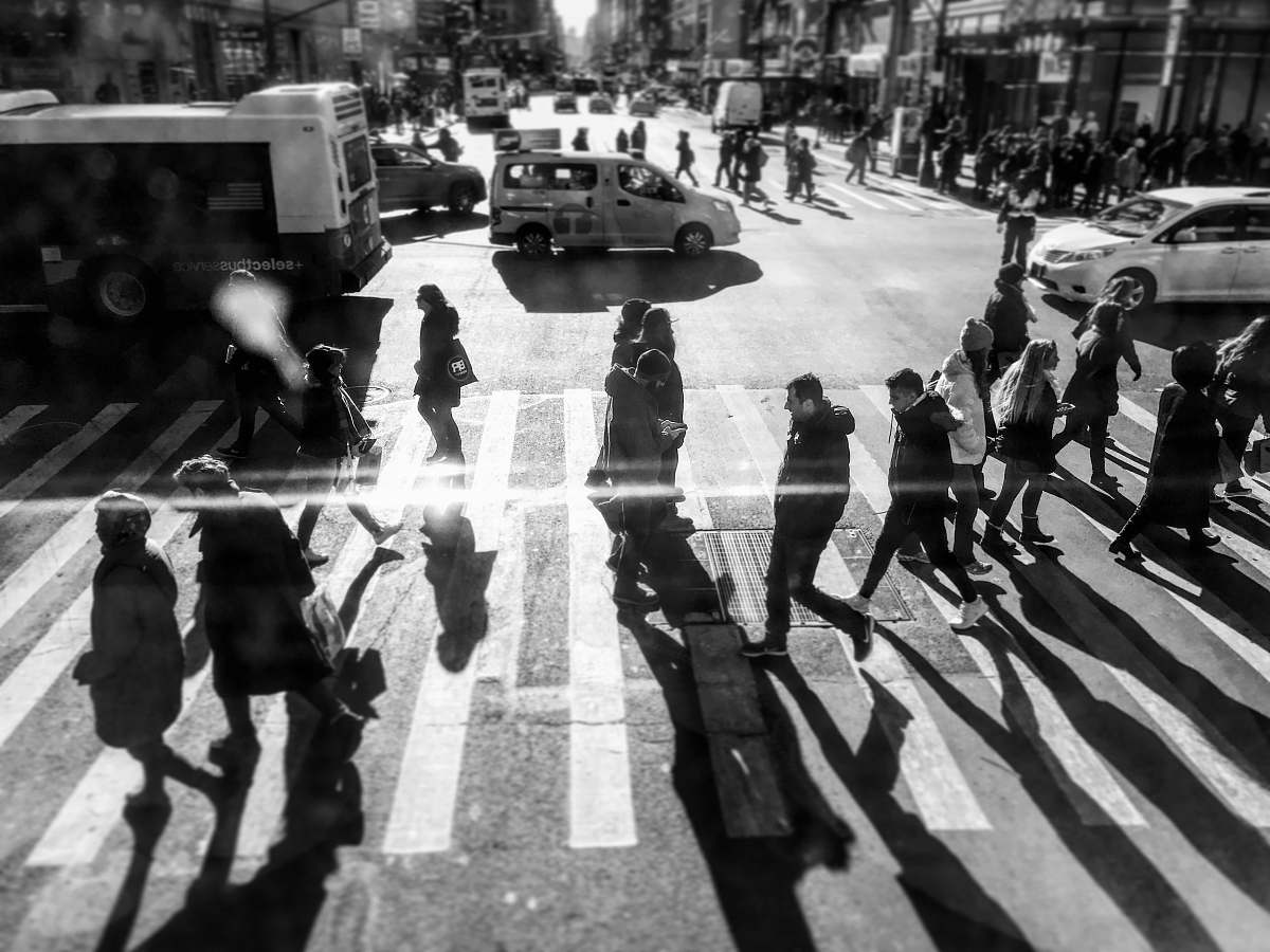 human grayscale photo of people passing by on pedestrian lane during daytime person
