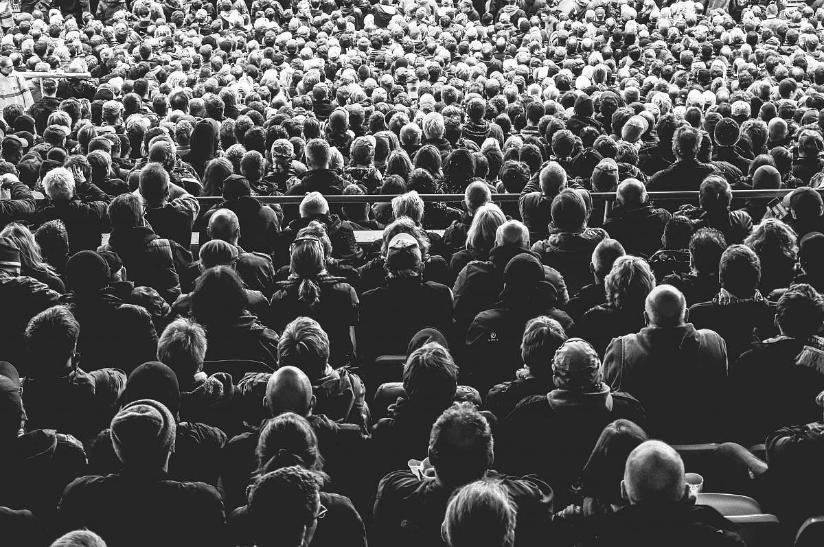 person grayscale photo of people sitting on chair crowd