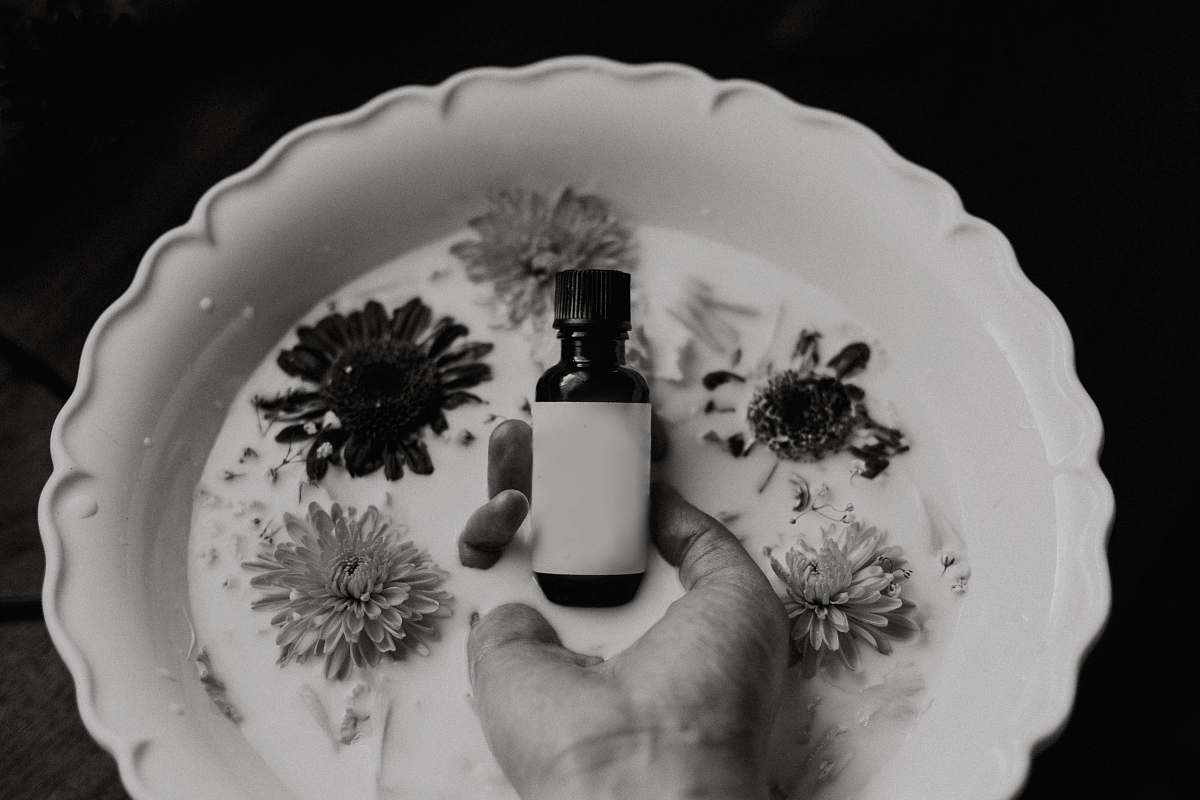 grey grayscale photo of person holding bottle bottle