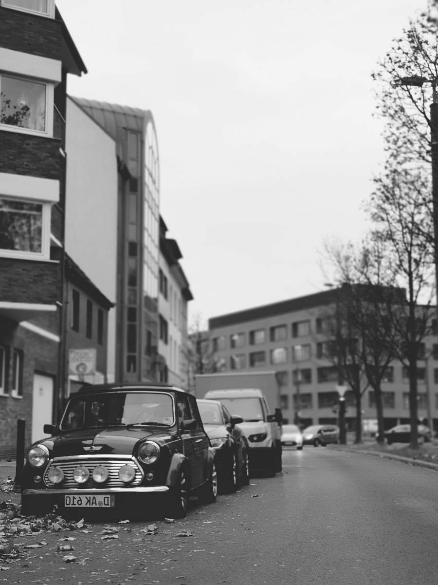 automobile grayscale photo of vehicles parked near buildings car