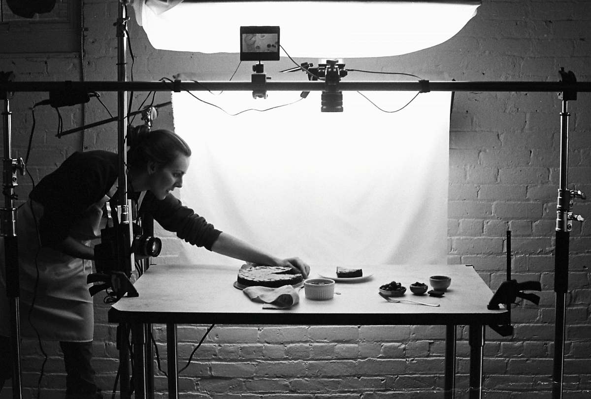 human grayscale photo of woman holding baking pan person