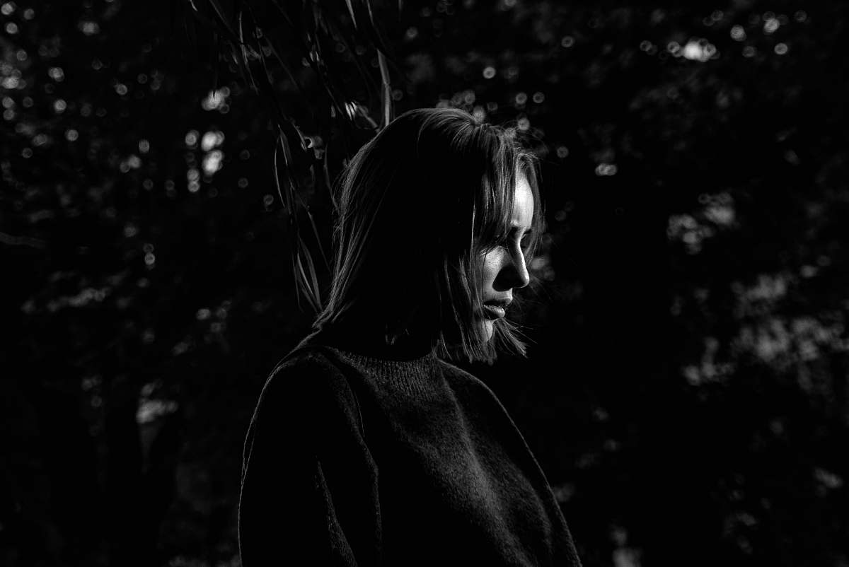 apparel grayscale photo of woman in long-sleeved shirt clothing
