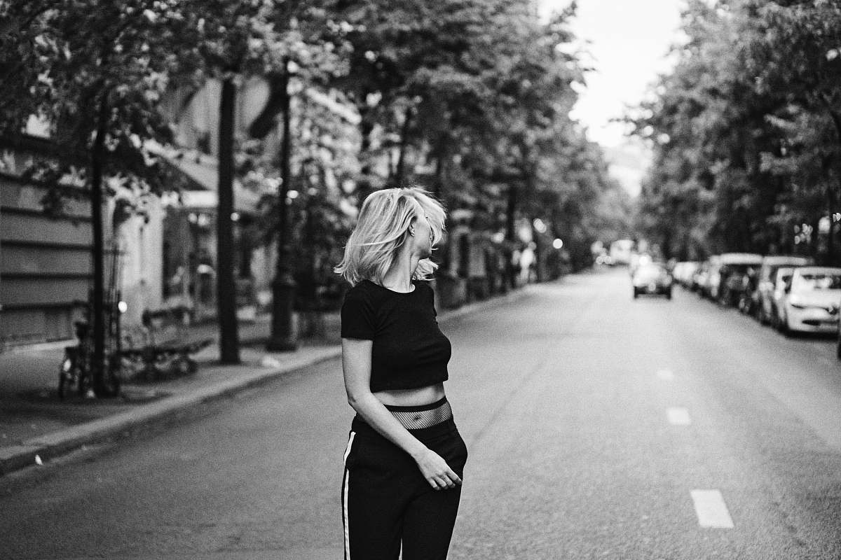 woman grayscale photo of woman leaning back standing on street blonde