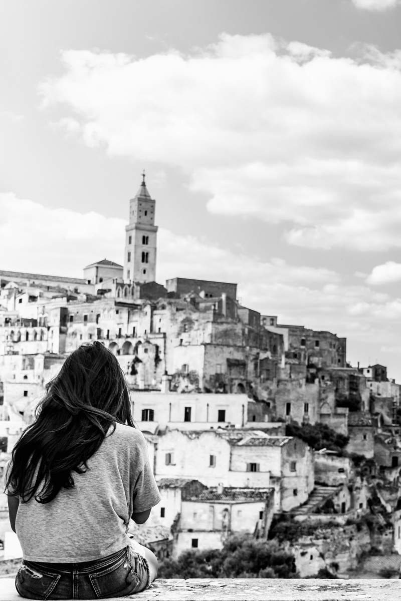 building grayscale photo of woman looking at cathedral human