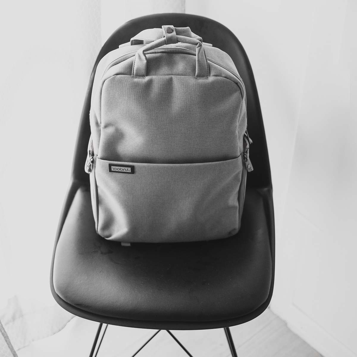 bag grayscale photography of backpack on chair backpack