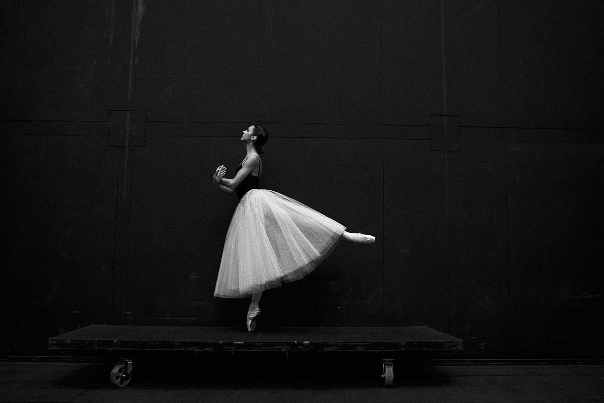 dance grayscale photography of ballet dancer standing on board ballet