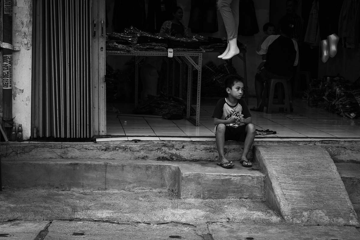 human grayscale photography of boy sitting on stairs person