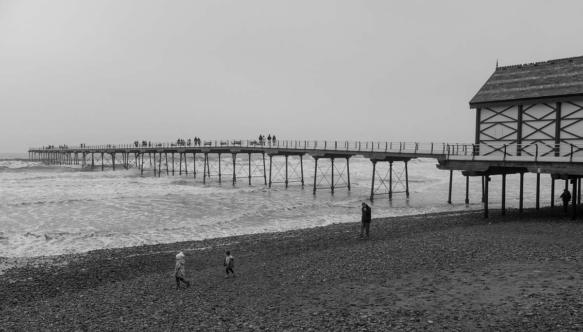 water grayscale photography of bridge surrounded by body of water pier
