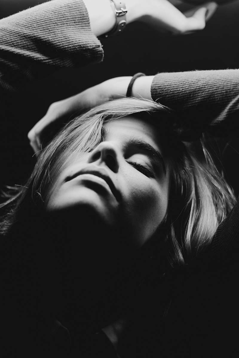 person grayscale photography of closed eyes woman while raising hands face