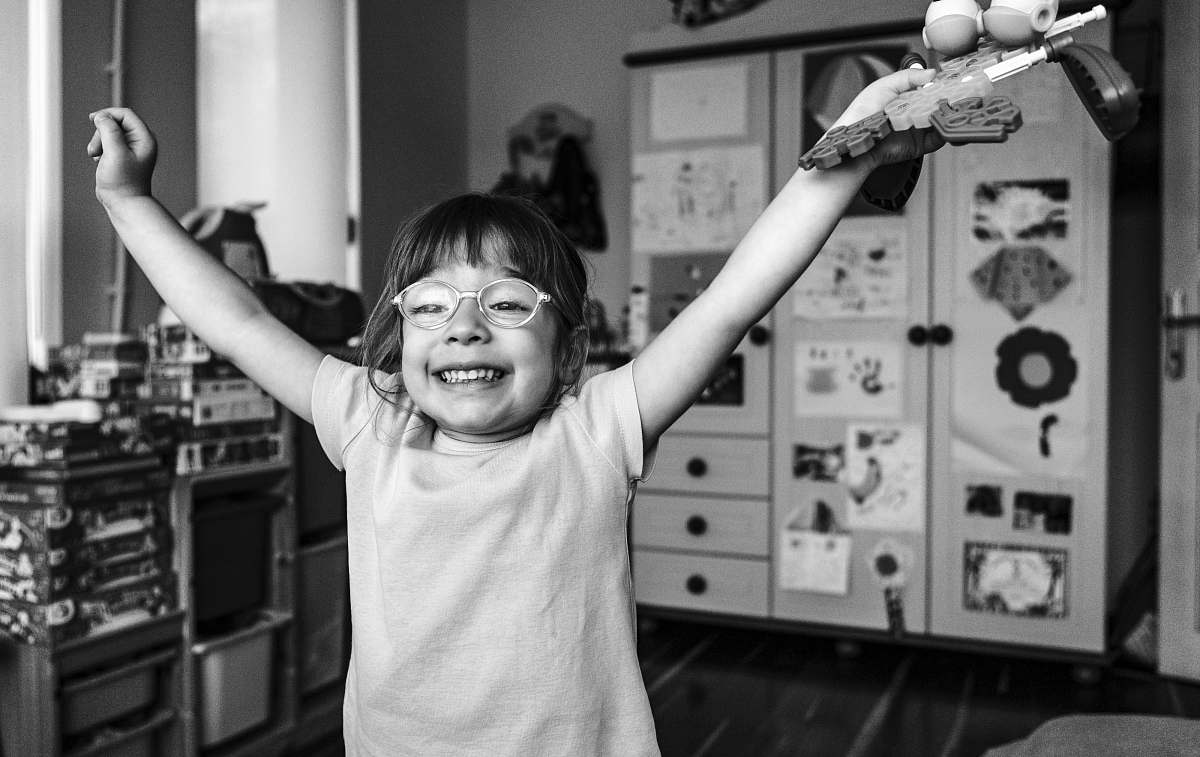 human grayscale photography of girl raising both hands smiling person