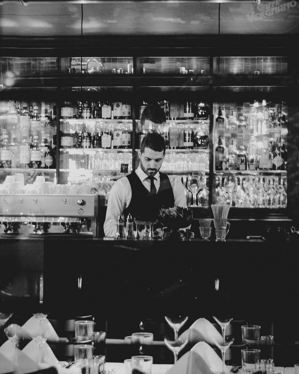 human grayscale photography of man holding wine glass person