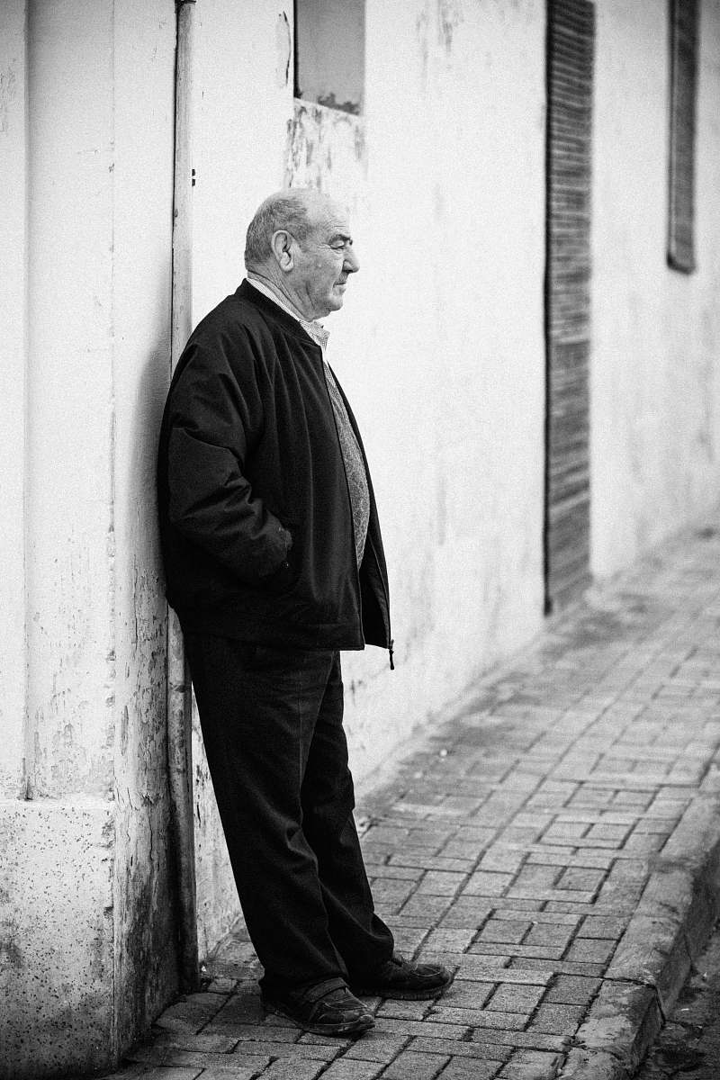 apparel grayscale photography of man leaning against wall clothing