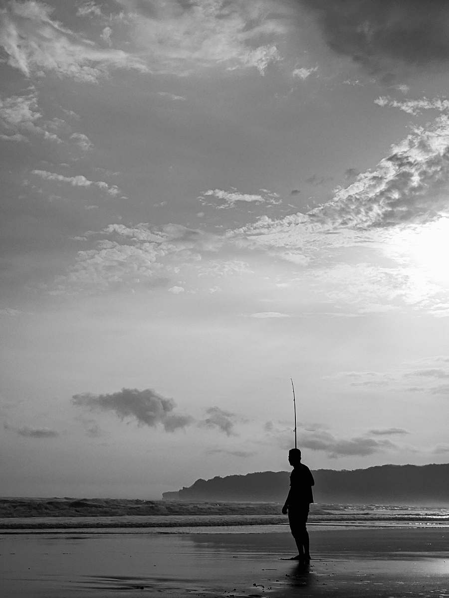 person grayscale photography of man on seashore grey