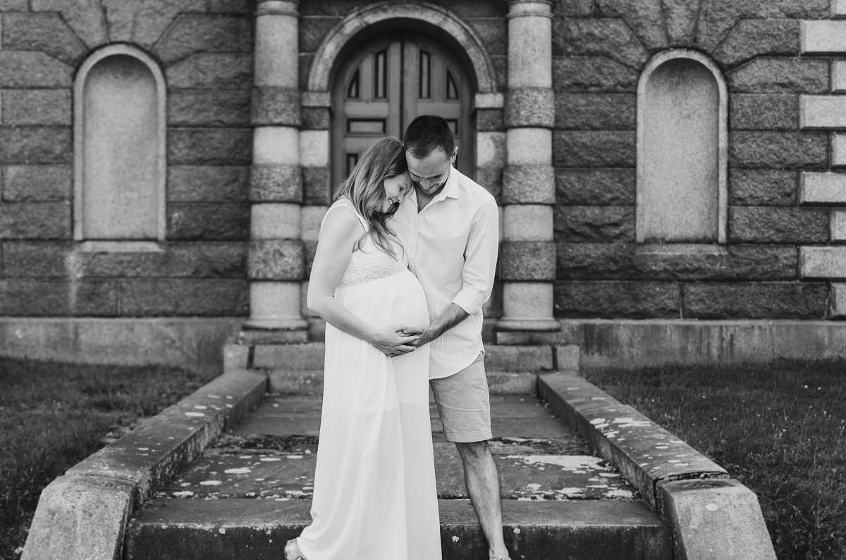 grey grayscale photography of man touching woman's pregnant belly apparel