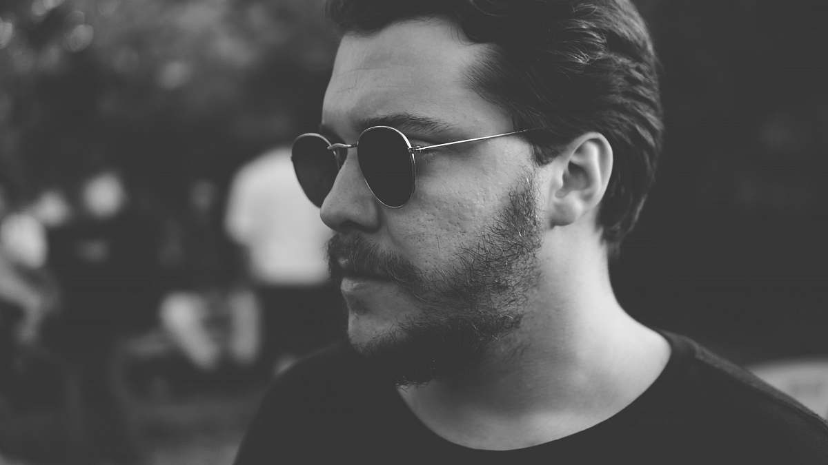 human grayscale photography of man wearing sunglasses grey