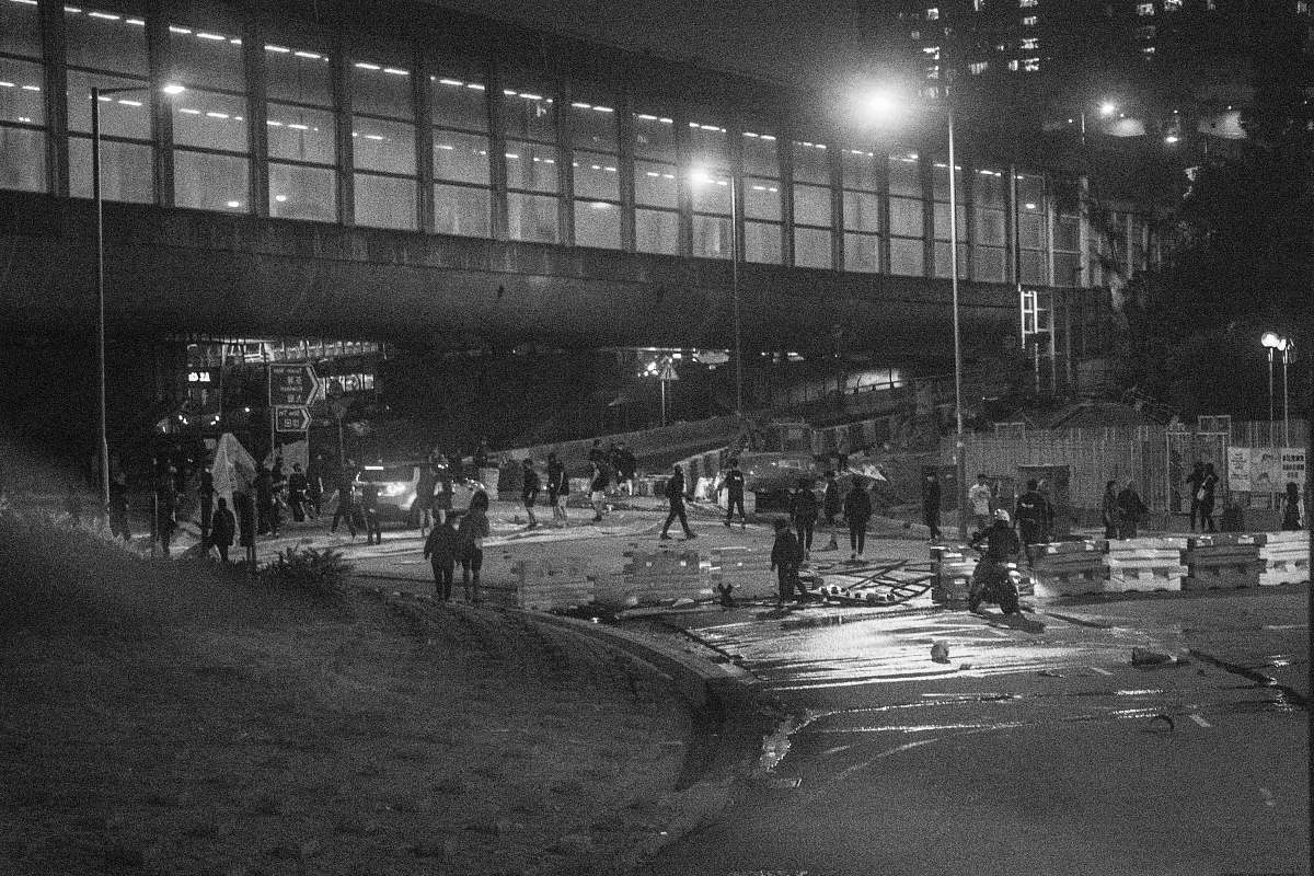 human grayscale photography of people near road and glass building grey