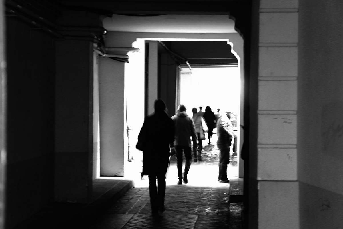 human grayscale photography of people walking on hallway corridor