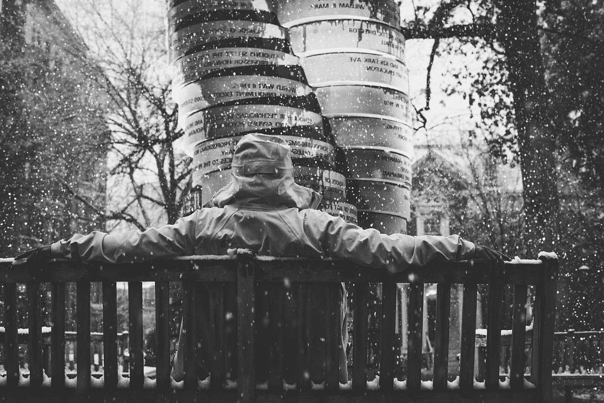 grey grayscale photography of person sitting on bench richmond