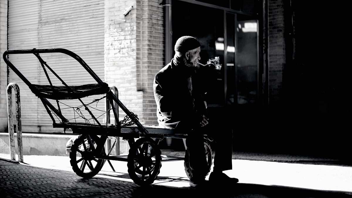 human grayscale photography of person sitting on trailer person