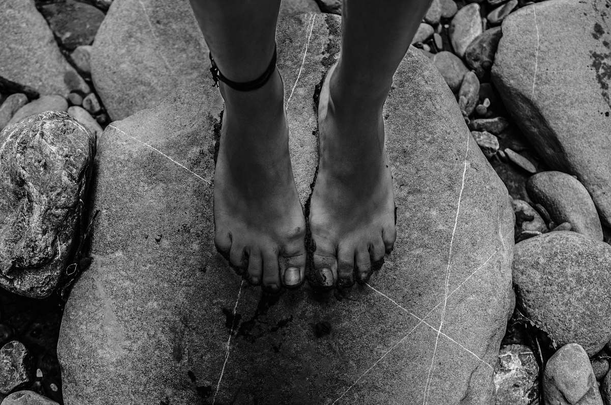 rock grayscale photography of person standing on rock albania