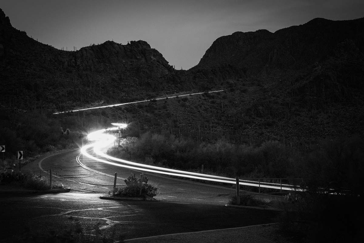 road grayscale photography of road beside mountain freeway