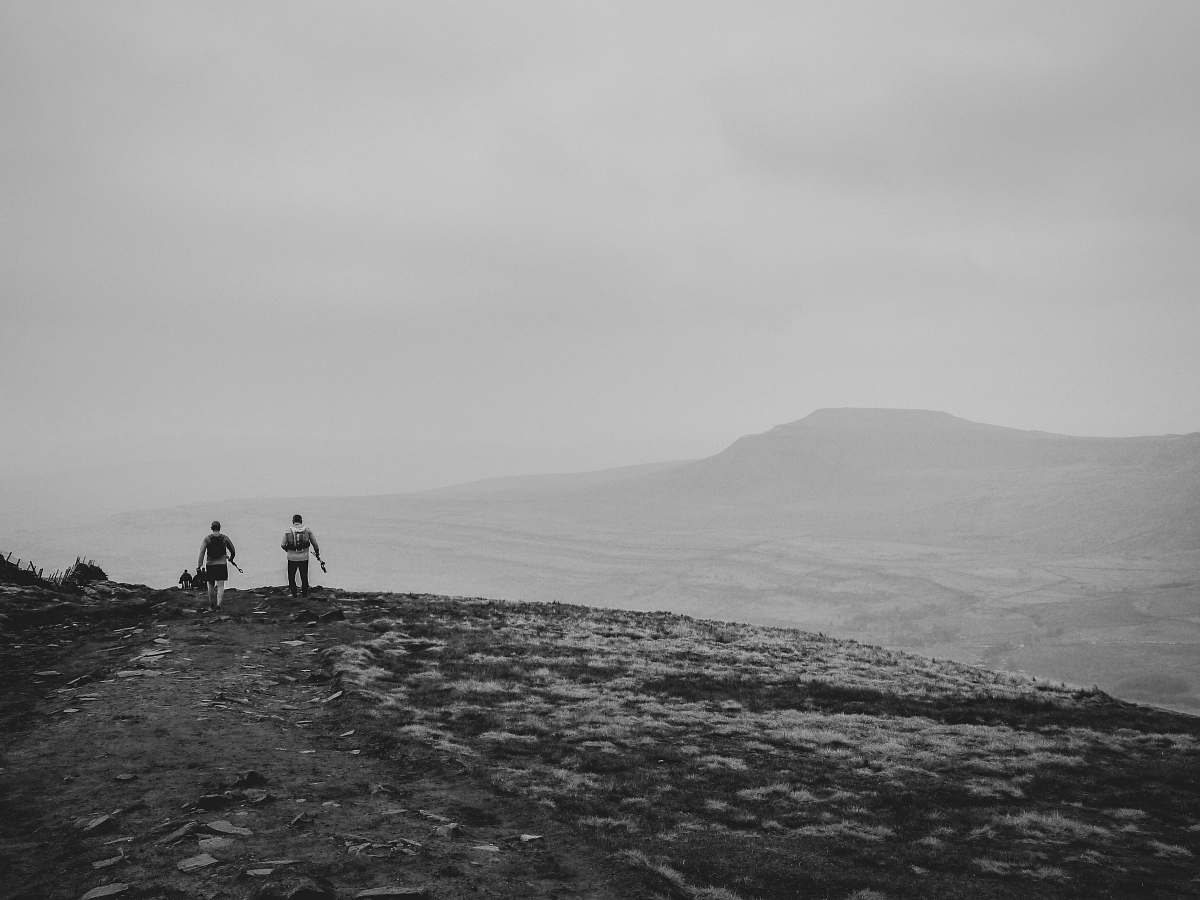 human grayscale photography of two people on cliff nature