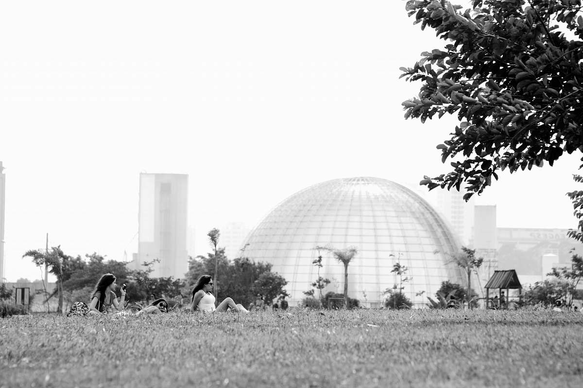 human grayscale photography of two women sitting on grass person