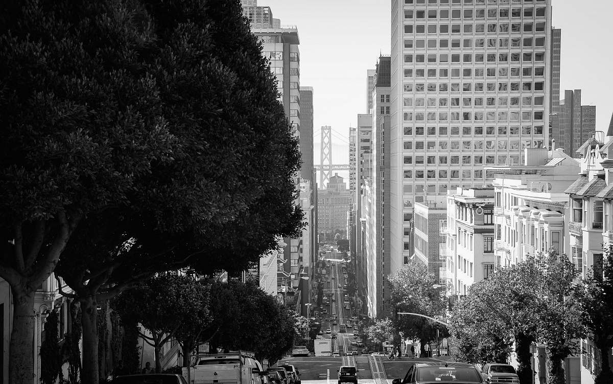 city grayscale photography of vehicle traveling on road during daytime downtown