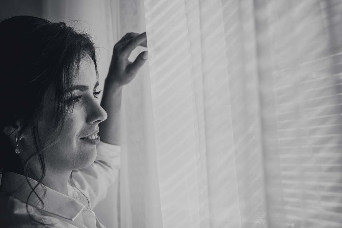 grey grayscale photography of woman near window human