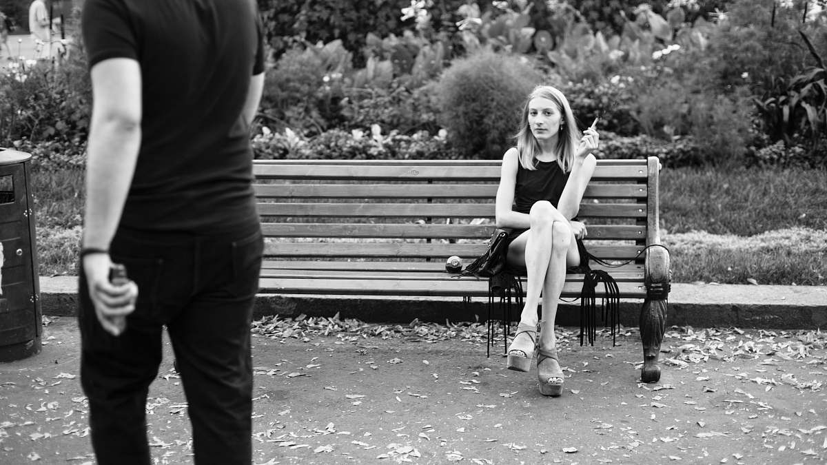 human grayscale photography of woman sitting near man person