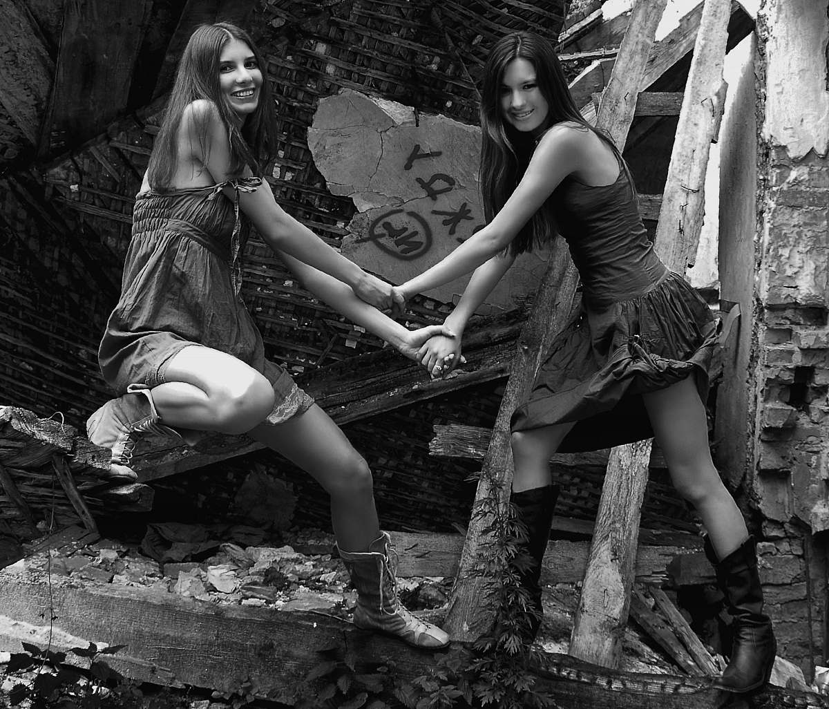 person grayscale photography two women holding hands outdoors human