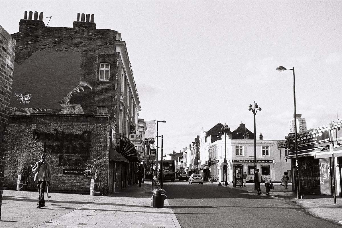 human greyscale photo of buildings path